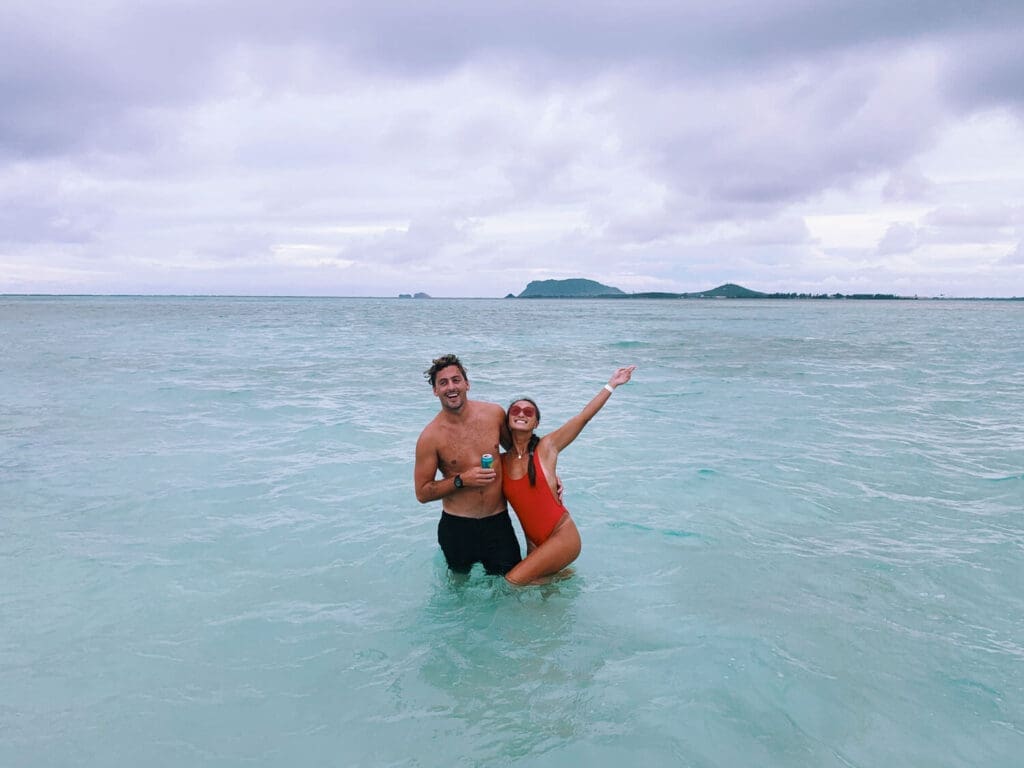 Couple in the middle of Kaneohe Sandbar at sunset