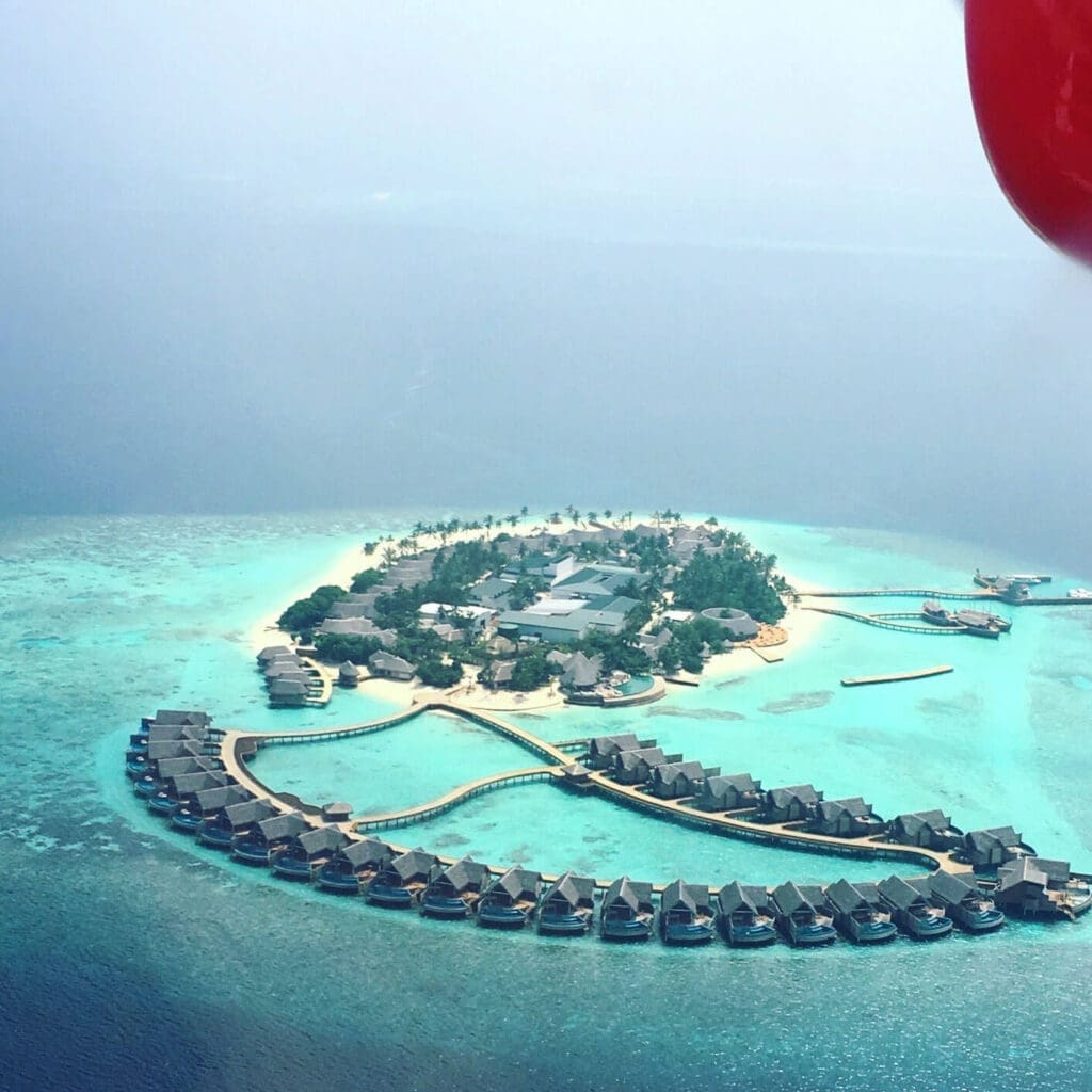 Seaplane flying over bungalows in the Maldives