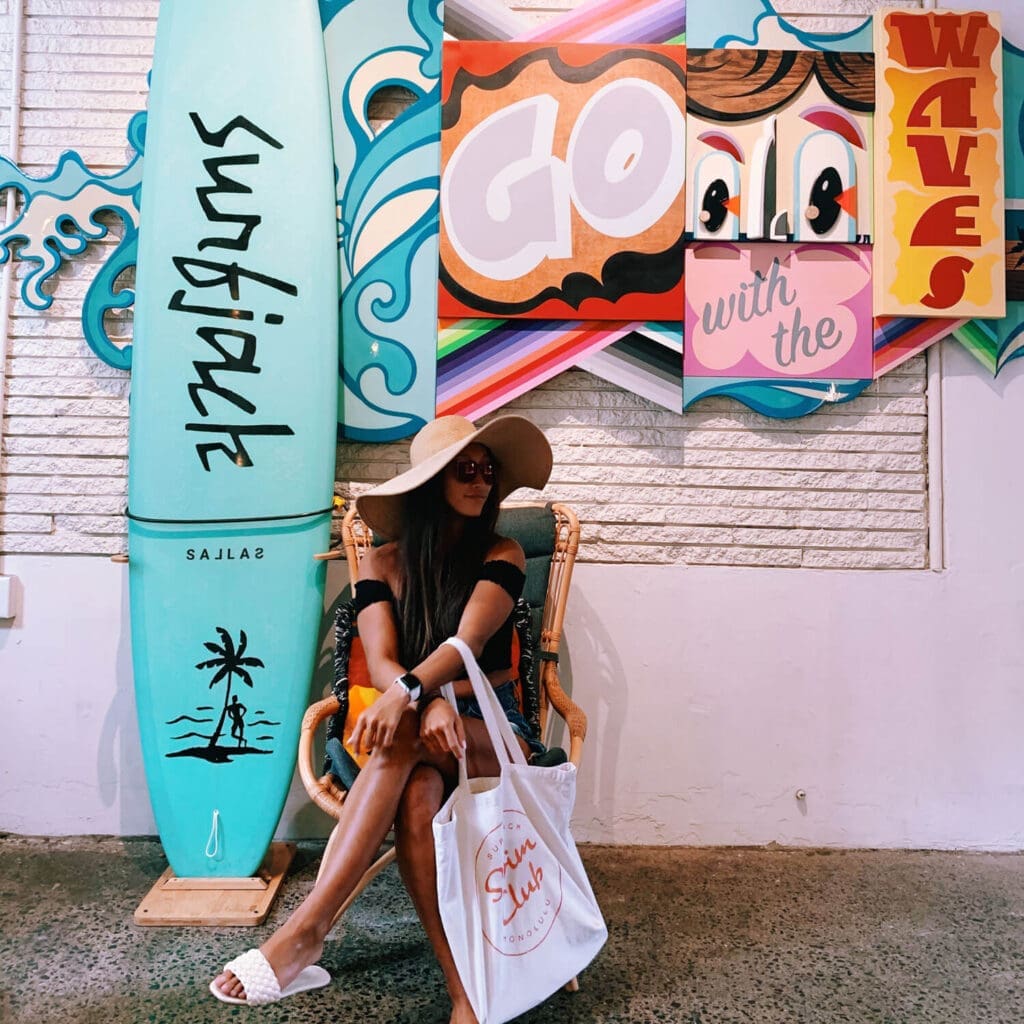 Girl on vacation sitting in the lobby of Surfjack Hotel, Waikiki