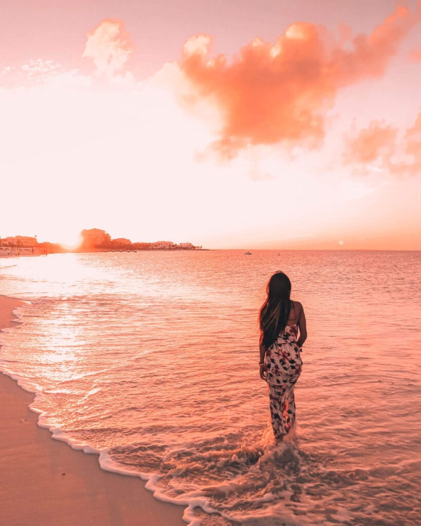 Girl standing in ocean during sunset in Turks and Caicos