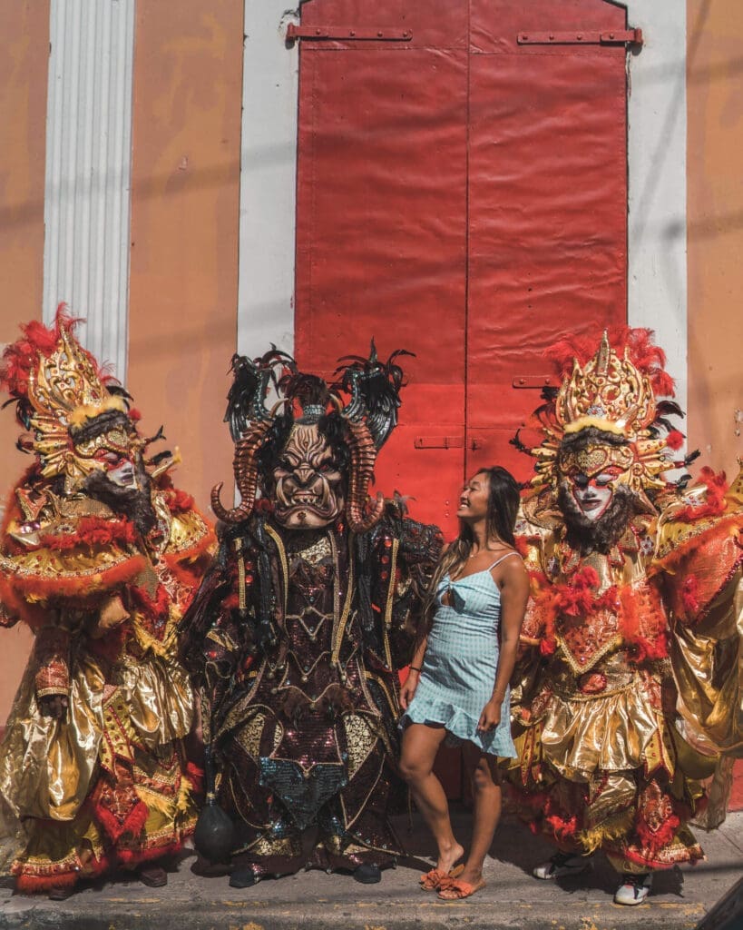 Girl standing with three Carnival costume characters