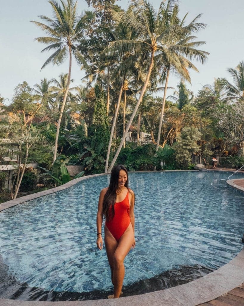 Girl in red swimsuit enjoys the swimming pool at Platran Hotel Ubud, Bali