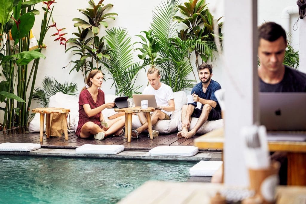 Digital nomads working poolside at Outpost Canggu in Bali 