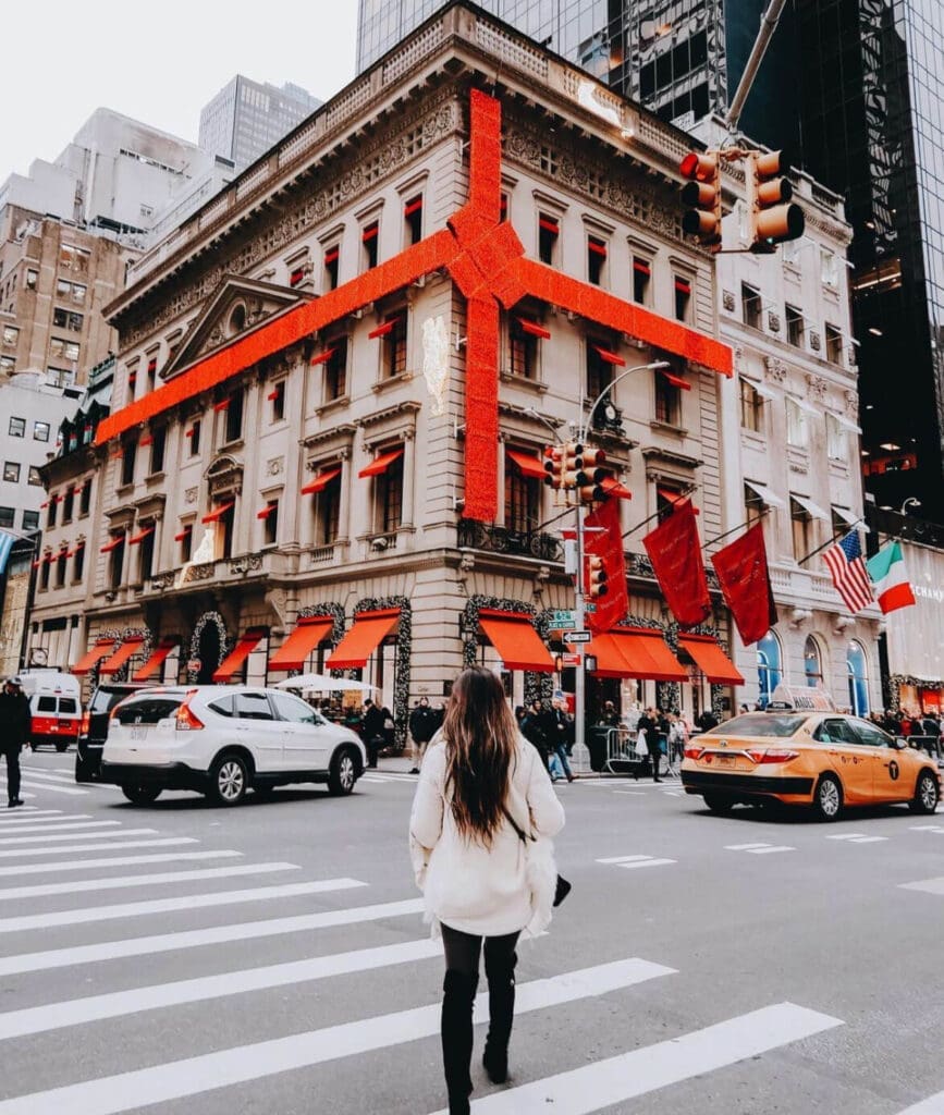 Girl standing in front of a Christmas storefront on 5th ave