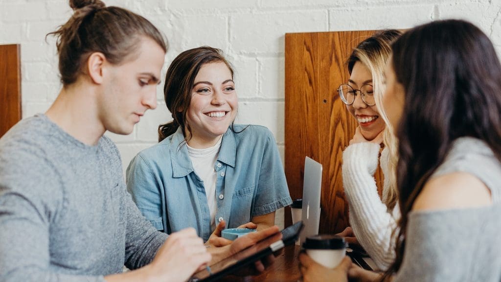 4 smiling entrepreneurs network over coffee