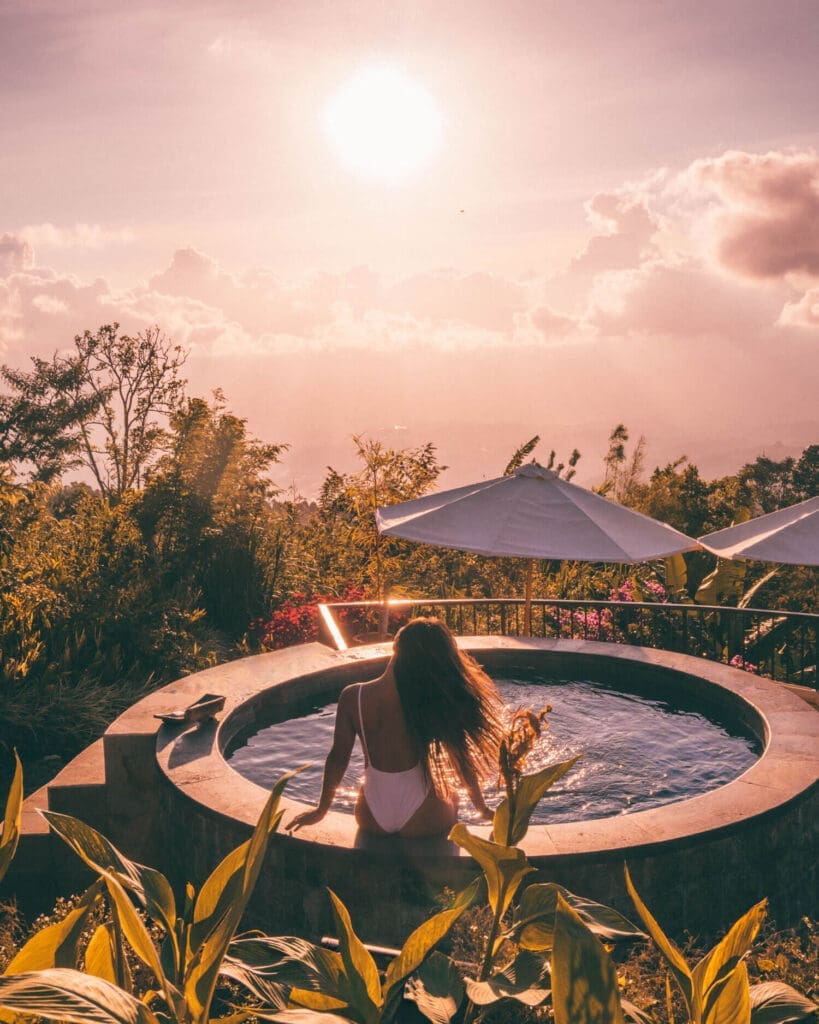 Girl sitting in a hot tub surrounded by plants