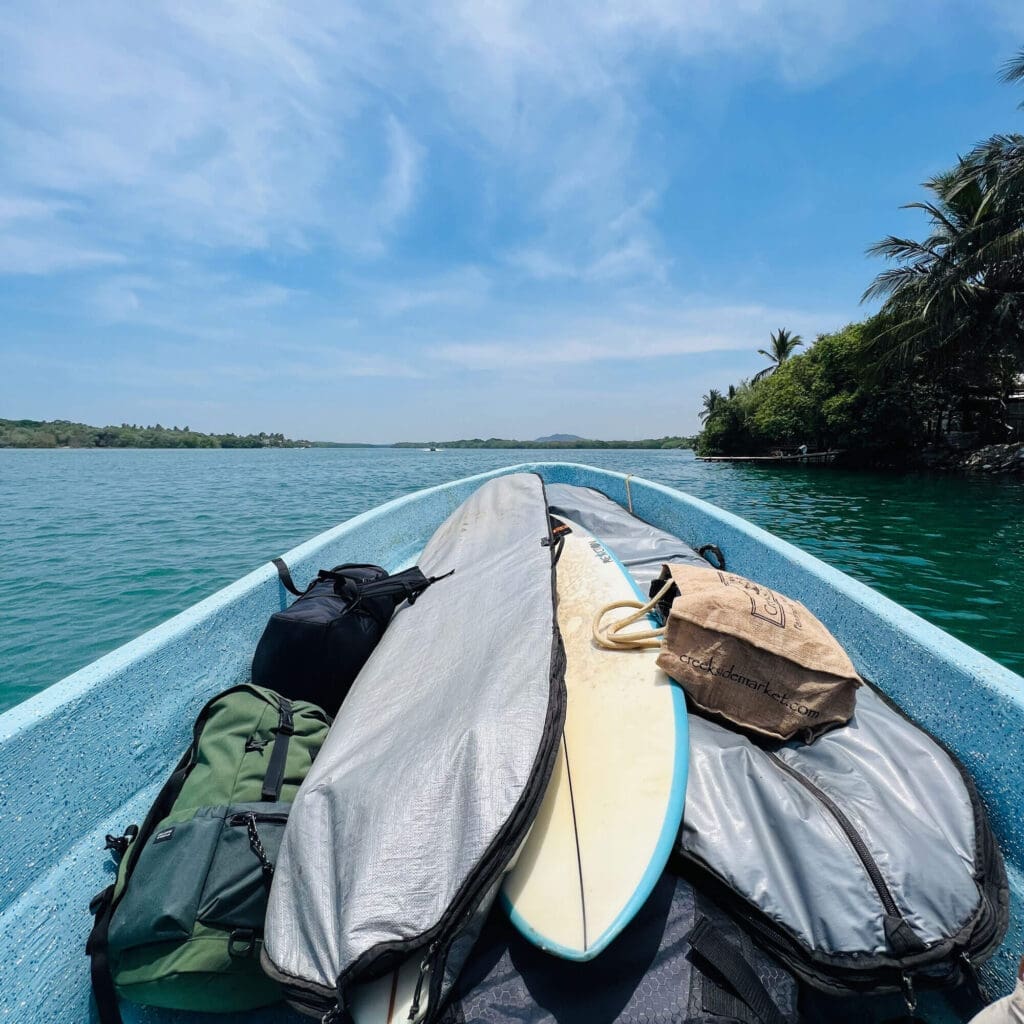 Boat with surfboards through the mangroves