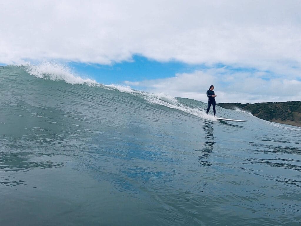 Girl longboarding a wave breaking left at Praia do Rosa