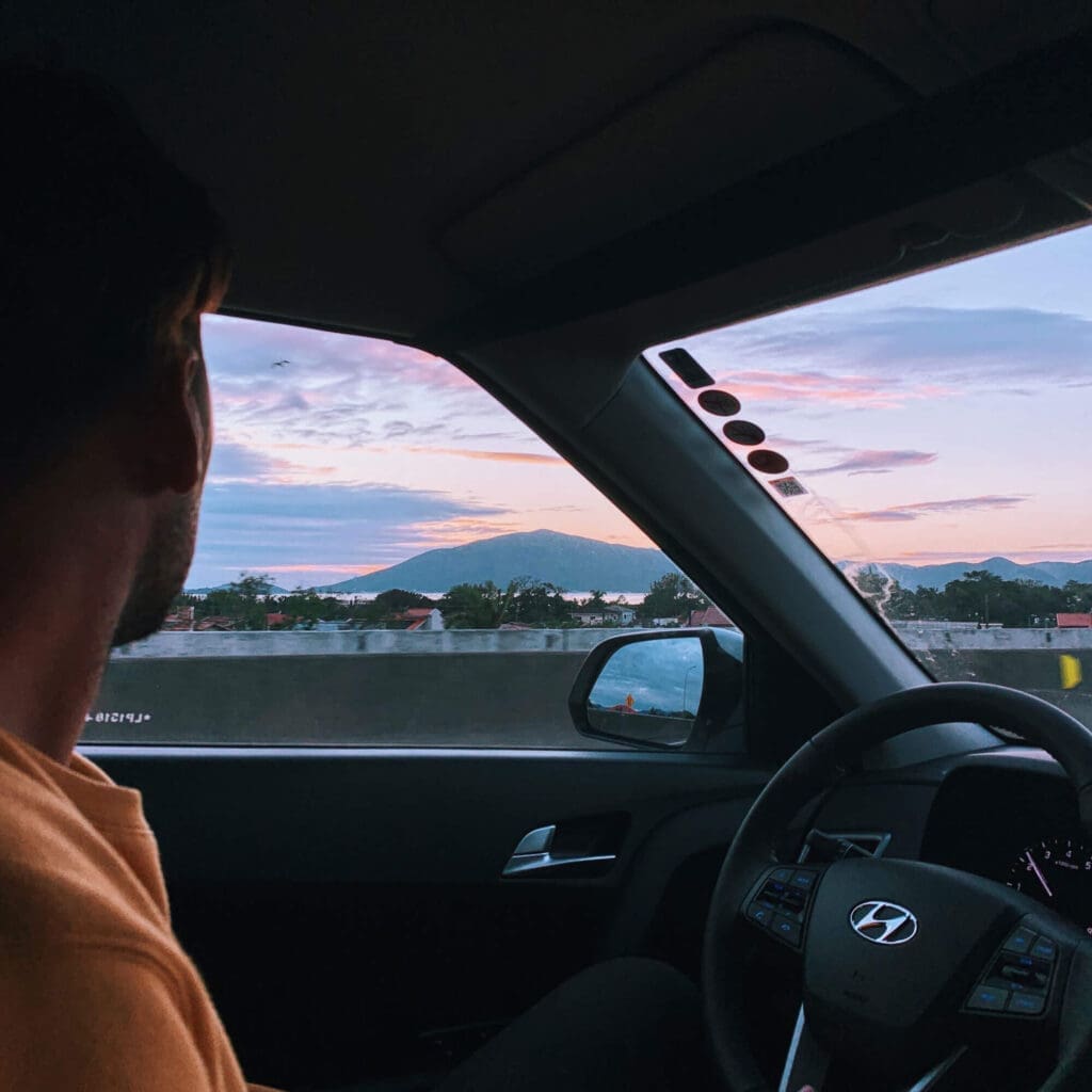 Man in car road tripping from Florianopolis to Praia do Rosa