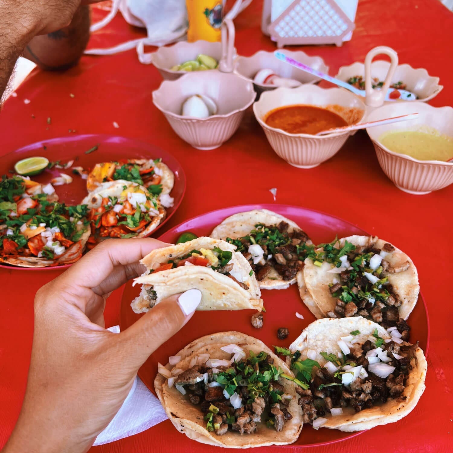 Six tacos on a red table