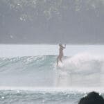 Girl hanging 5 on longboard in Nias Indonesia