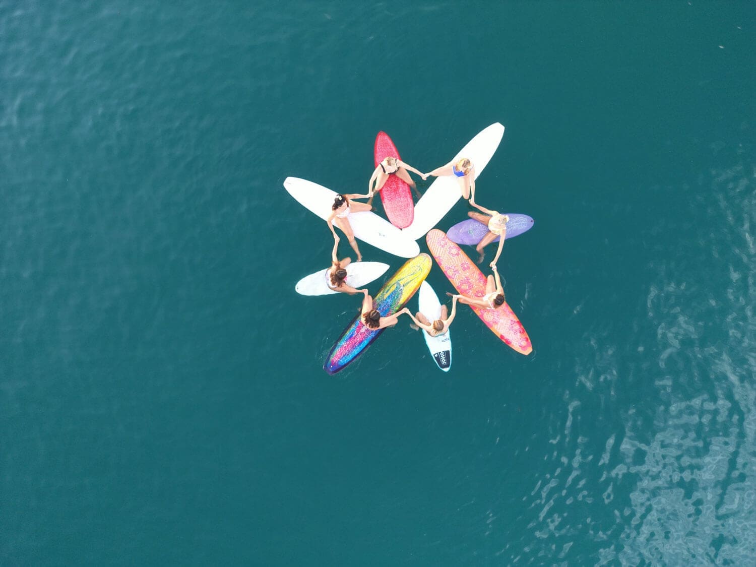 Drone photo of surfers and longboarders in a circle